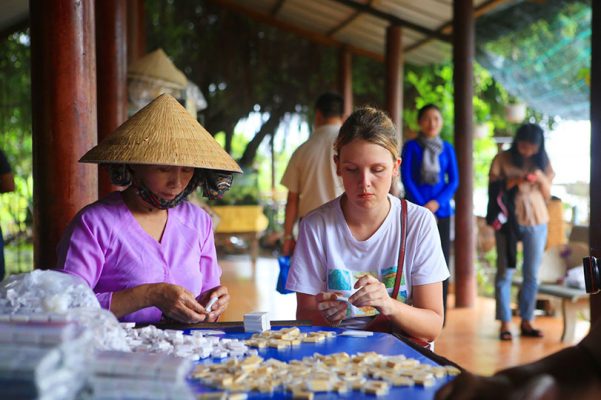 Tourists learn to make coconut candy.