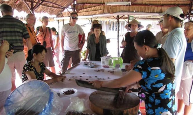 Tourists enjoy seeing coconut candy production.