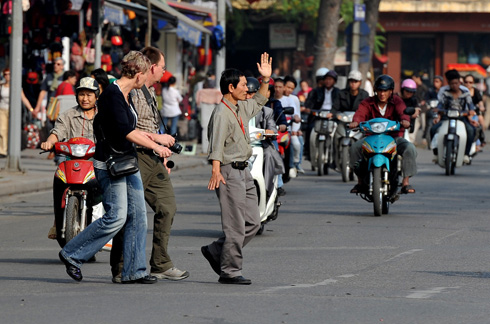 When crossing the street, look and signal to oncoming vehicles.